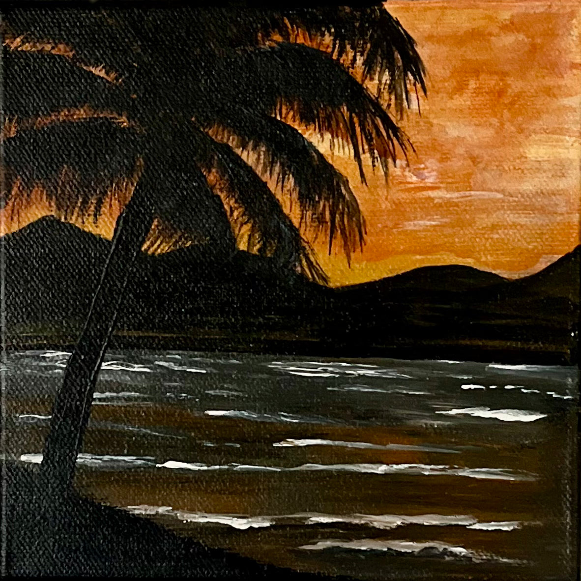 Canvas art Acrylic seascape painting titled “Sunset in Paradise”. Silhouette palm tree and mountains with ocean mirroring the orange sunset sky.